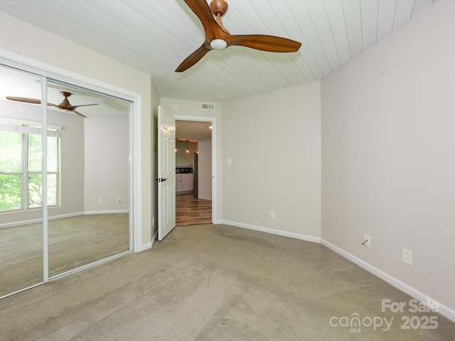 unfurnished bedroom with visible vents, a closet, baseboards, ceiling fan, and light colored carpet