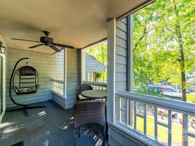 sunroom featuring a ceiling fan, a healthy amount of sunlight, and a water view