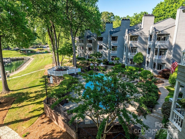 surrounding community with a water view, a yard, and a vegetable garden