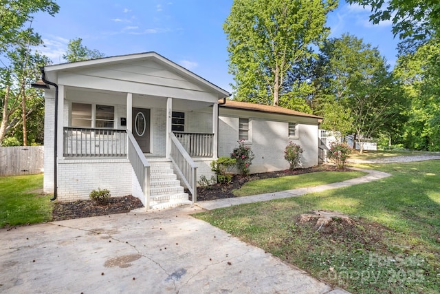 view of front of house with covered porch, brick siding, and a front yard