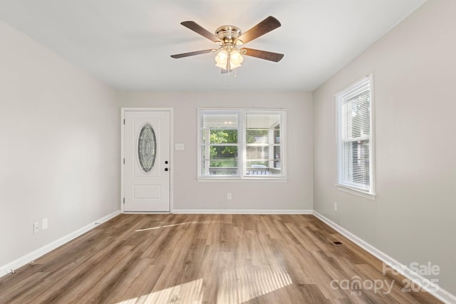 foyer featuring baseboards, a ceiling fan, and wood finished floors