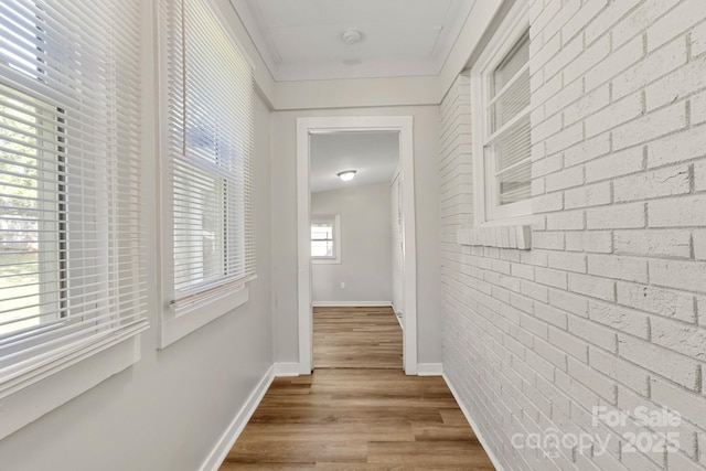 corridor with baseboards and wood finished floors