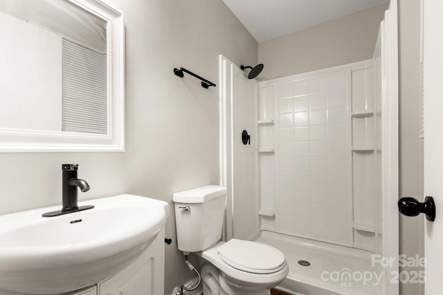 bathroom with vanity, toilet, and tiled shower