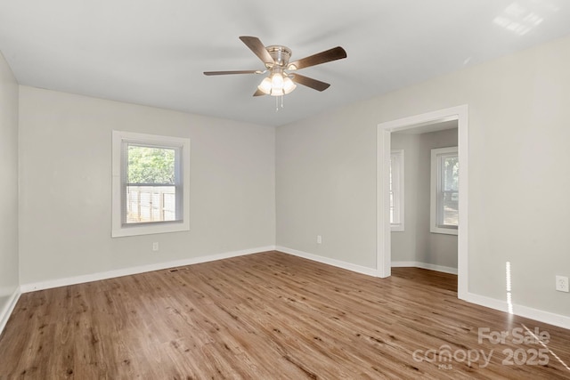 unfurnished room featuring a ceiling fan, baseboards, and wood finished floors