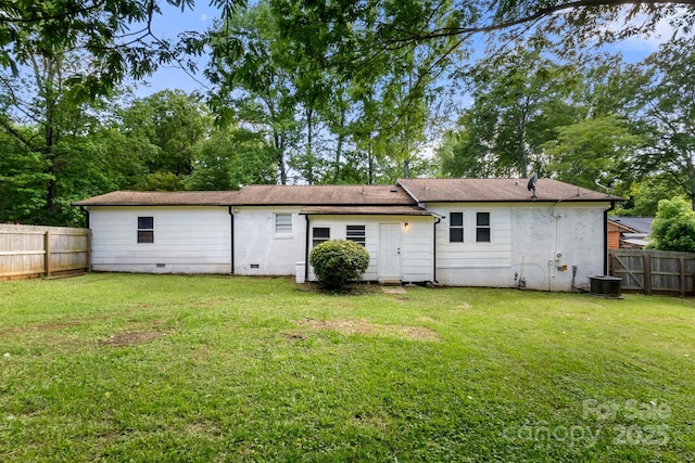 back of property featuring a fenced backyard, a lawn, brick siding, and crawl space