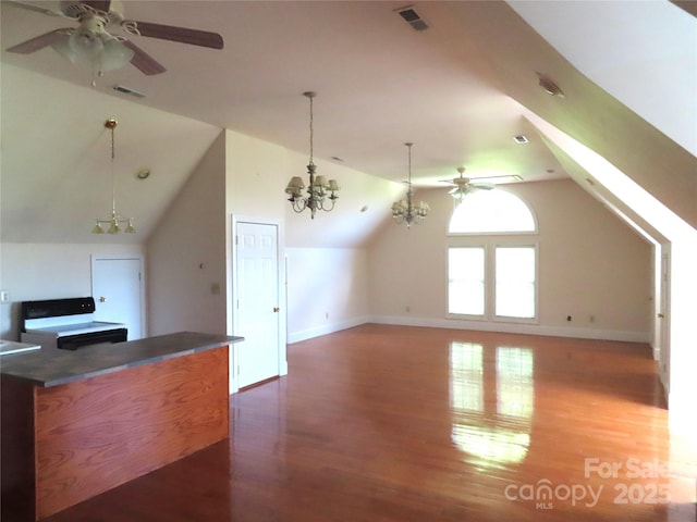 additional living space featuring vaulted ceiling, wood finished floors, ceiling fan with notable chandelier, and visible vents
