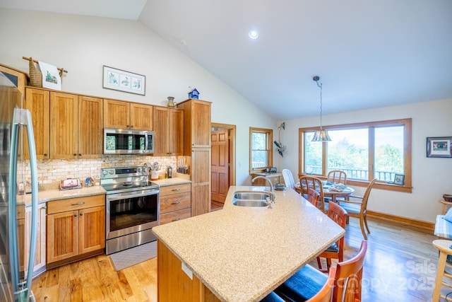 958 Alta Vista Ln, Sparta, NC 28675 - kitchen featuring a kitchen breakfast bar, appliances with stainless steel finishes, tasteful backsplash, a sink, and light wood-style flooring