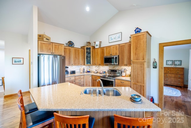 958 Alta Vista Ln, Sparta, NC 28675 - kitchen featuring wood finished floors, a breakfast bar, high vaulted ceiling, tasteful backsplash, and stainless steel appliances
