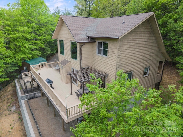 132 Vacation Way, Millers Creek, NC 28651 - view of home's exterior featuring a deck, outdoor dining space, roof with shingles, and an outbuilding