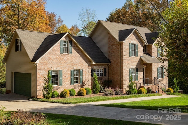 view of front facade with brick siding, a front lawn, concrete driveway, an attached garage, and a shingled roof