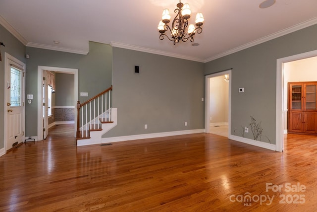 unfurnished living room with crown molding, a notable chandelier, and wood finished floors