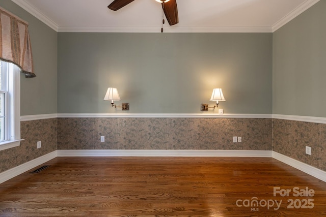 empty room with ceiling fan, visible vents, baseboards, and wood finished floors