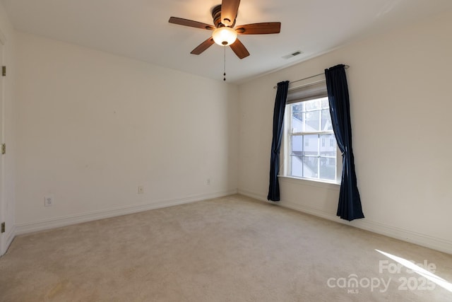 spare room with ceiling fan, visible vents, light carpet, and baseboards