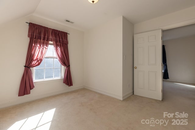 unfurnished bedroom with carpet flooring, baseboards, visible vents, and lofted ceiling