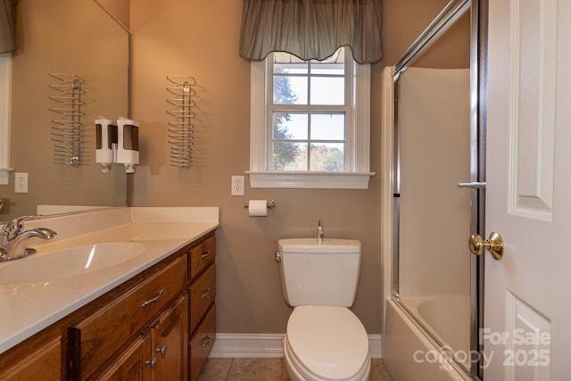 full bathroom with tile patterned flooring, vanity, toilet, baseboards, and enclosed tub / shower combo