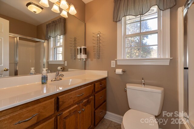 bathroom with baseboards, an enclosed shower, a wealth of natural light, and toilet