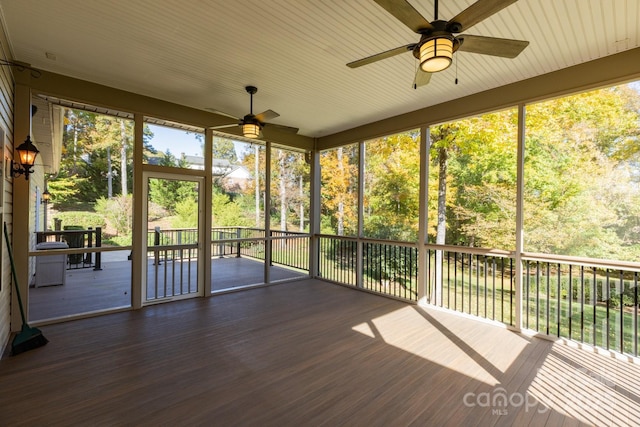 unfurnished sunroom featuring ceiling fan and a healthy amount of sunlight