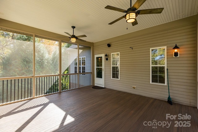 unfurnished sunroom featuring a ceiling fan