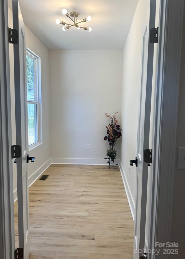 3114 Ansonville Rd, Marshville, NC 28103 - spare room featuring plenty of natural light, light wood-style flooring, baseboards, and a chandelier