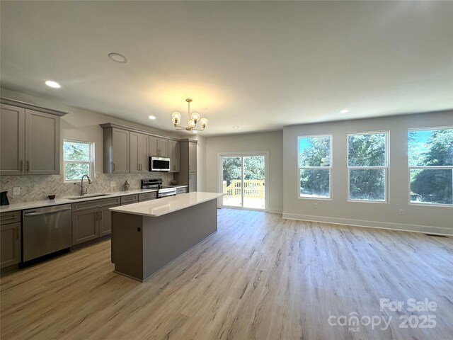 3114 Ansonville Rd, Marshville, NC 28103 - kitchen with stainless steel appliances, gray cabinets, a sink, a chandelier, and healthy amount of natural light