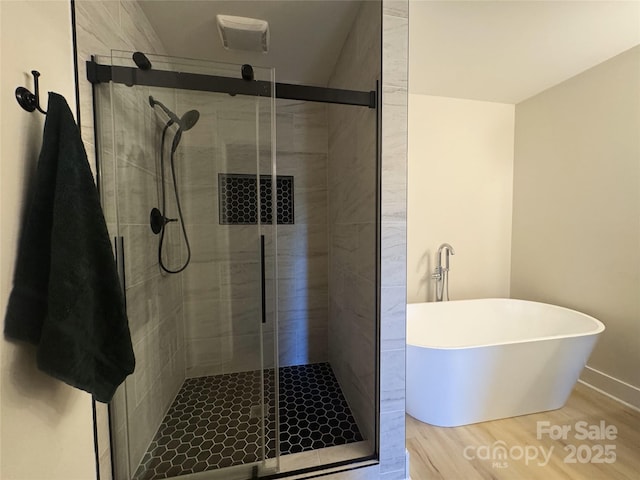 3114 Ansonville Rd, Marshville, NC 28103 - full bathroom with wood finished floors, a freestanding tub, a shower stall, and baseboards