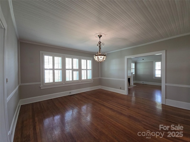 unfurnished dining area with crown molding, dark wood-style flooring, baseboards, and a notable chandelier