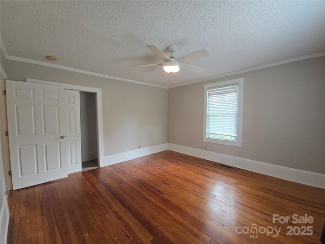unfurnished bedroom with visible vents, a textured ceiling, baseboards, and hardwood / wood-style floors