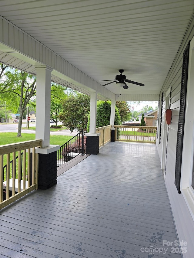 deck featuring a porch, ceiling fan, and a yard