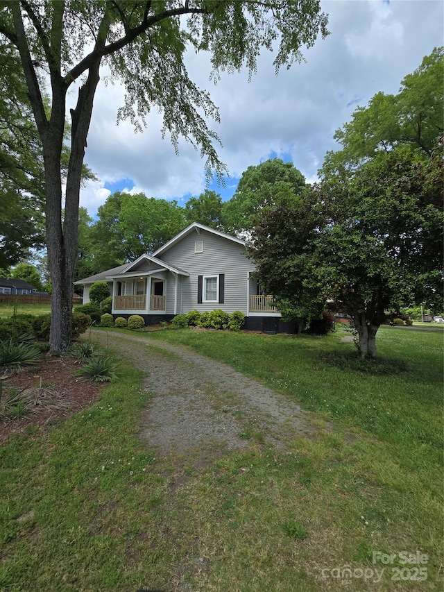 view of front of property featuring a porch, driveway, and a front yard