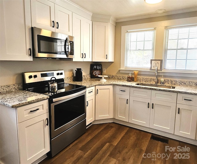 kitchen featuring dark wood-style flooring, visible vents, crown molding, appliances with stainless steel finishes, and white cabinets