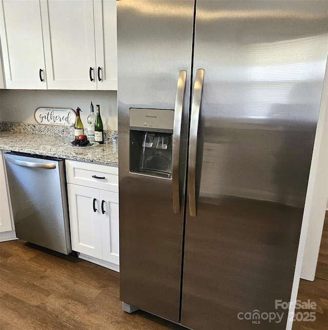 169 Freeze Ave NW, Concord, NC 28025 - kitchen featuring stainless steel appliances, dark wood-type flooring, white cabinets, and light stone counters