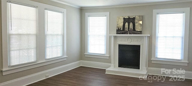 169 Freeze Ave NW, Concord, NC 28025 - unfurnished living room with dark wood-style flooring, ornamental molding, and a fireplace with raised hearth