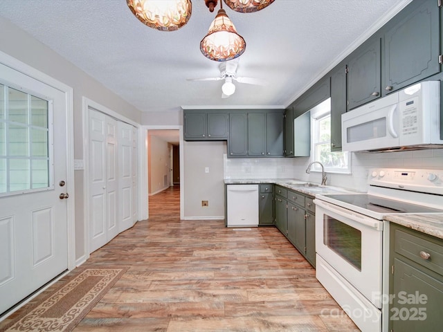 4901 Pine Oaks Dr, Monroe, NC 28112 - kitchen featuring decorative backsplash, white appliances, light wood-style floors, ceiling fan, and a sink