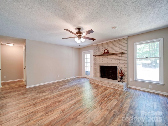4901 Pine Oaks Dr, Monroe, NC 28112 - unfurnished living room featuring a ceiling fan, a textured ceiling, a brick fireplace, baseboards, and light wood finished floors