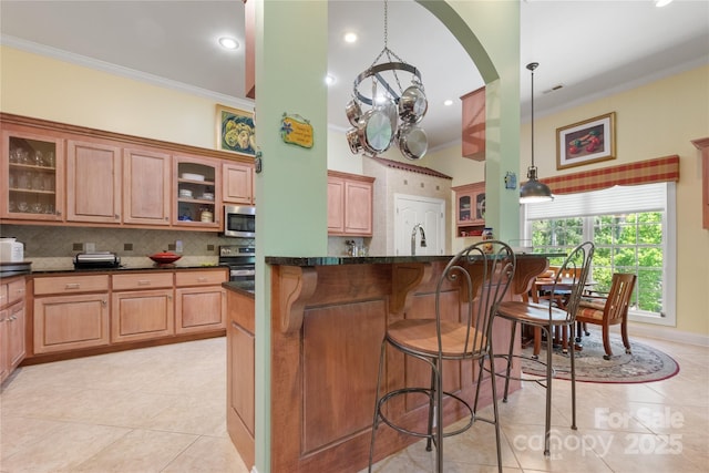 5342 Beacon Ridge Dr, Granite Falls, NC 28630 - kitchen with appliances with stainless steel finishes, light tile patterned flooring, ornamental molding, a kitchen breakfast bar, and tasteful backsplash