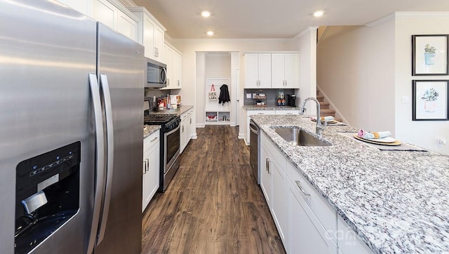kitchen with a sink, stainless steel appliances, white cabinetry, dark wood-type flooring, and ornamental molding