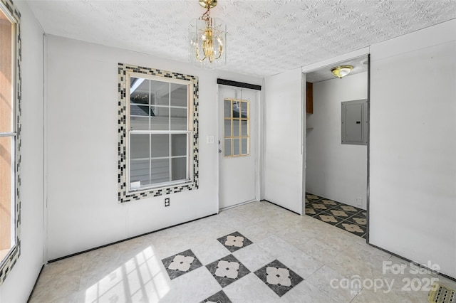 unfurnished room with a notable chandelier and electric panel