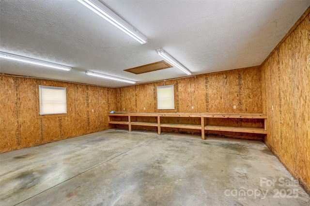 basement with wooden walls and a textured ceiling