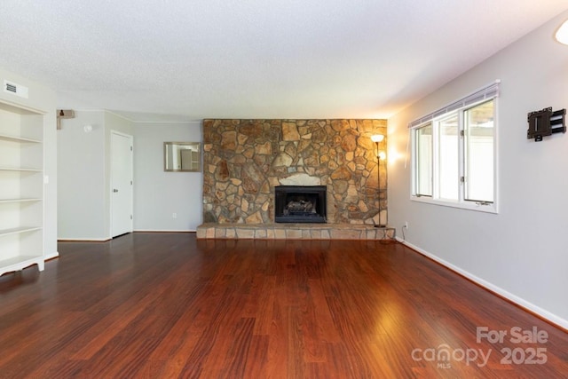 87 Marion Forest Rd Unit 8, Sylva, NC 28779 - unfurnished living room with baseboards, a stone fireplace, built in shelves, and wood finished floors