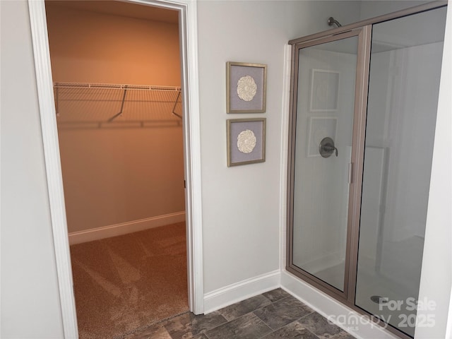 704 Robert Moses Dr Unit 121, Gastonia, NC 28056 - bathroom with a walk in closet, baseboards, and a stall shower