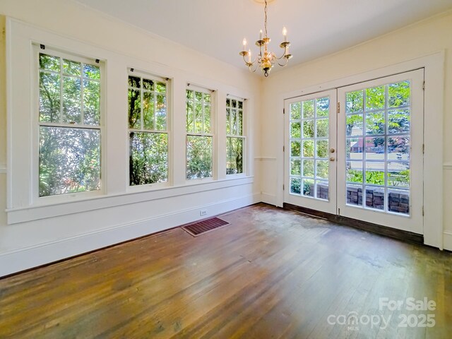 empty room featuring a chandelier and dark wood-type flooring