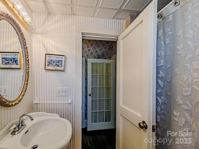 full bathroom with a sink and wallpapered walls