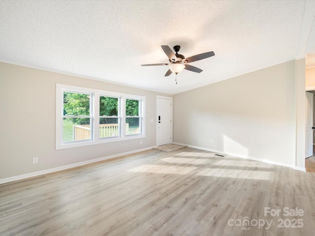 empty room with a ceiling fan, baseboards, light wood finished floors, and a textured ceiling