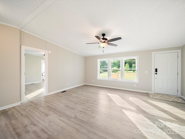unfurnished living room with a ceiling fan, ornamental molding, light wood-style flooring, baseboards, and a textured ceiling