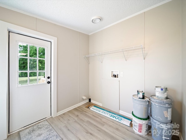 washroom featuring light wood-style floors, washer hookup, ornamental molding, a textured ceiling, and baseboards