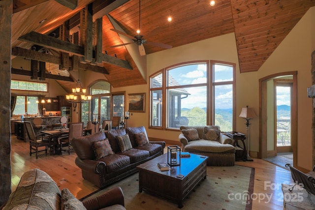 living area featuring wood ceiling, ceiling fan with notable chandelier, hardwood / wood-style floors, and high vaulted ceiling
