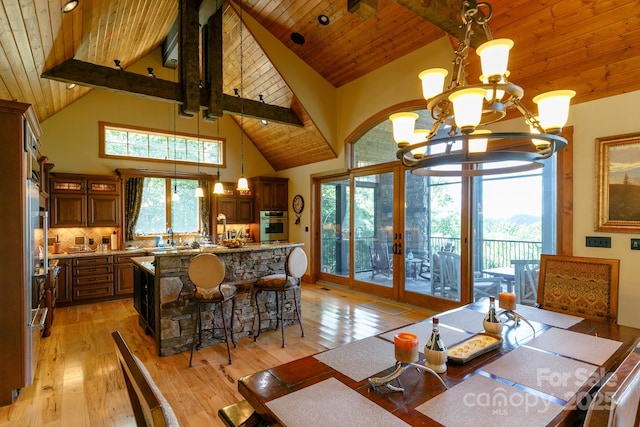 dining room with an inviting chandelier, wood ceiling, and french doors