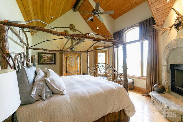 bedroom with wooden ceiling, beam ceiling, a fireplace, and multiple windows
