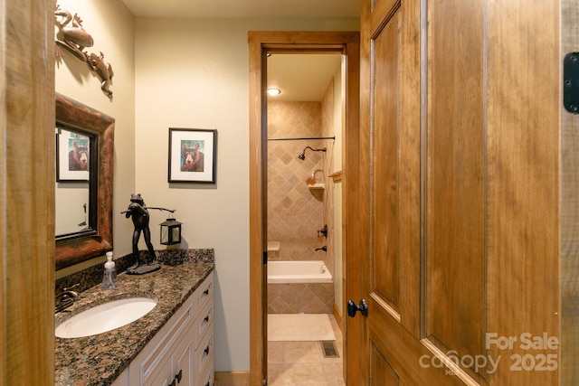 full bath featuring vanity, tiled shower / bath combo, visible vents, and tile patterned floors