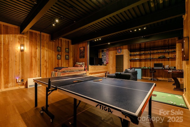game room with beam ceiling, wooden walls, and wood finished floors